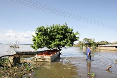 A man wades through a flooded street in Las Galderas, Venezuela, August 8, 2017. Picture taken August 8, 2017. REUTERS/William Urdaneta