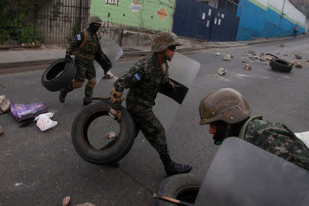 Soldiers remove tires of a barricade, during a protest against the re-election of Honduras' President Juan Orlando Hernandez in Tegucigalpa, Honduras January 20, 2018. REUTERS/Jorge Cabrera