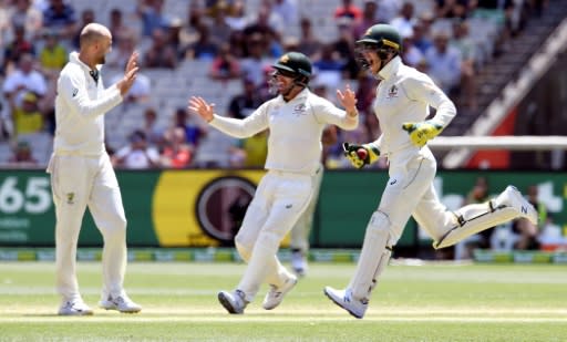 Australia's Nathan Lyon (left), Joe Burns and wicketkeeper Tim Paine (R) celebrate the stumping of New Zealand batsman Henry Nicholls