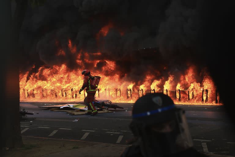 Un socorrista llega a un incendio provocado frente a un edificio durante una manifestación, el lunes 1 de mayo de 2023 en París.