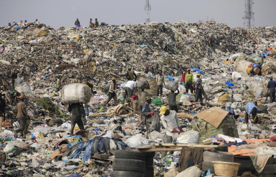 In this photo taken Friday, Jan, 24. 2014, scavengers in Lagos, Nigeria sort out iron and plastic to sell at the Olusosun dump site the city's largest dump. With a population of more than 20 million, garbage piles up on streets, outside homes and along the waterways and lagoons, creating eyesores and putrid smells. The booming city also has major electricity shortages and many residents rely on diesel generators that cloud the air with black exhaust. Nigeria's most populous city is turning these problems into an advantage by starting a program to convert waste into methane gas to generate electricity. A pilot program at a local market has already shown success on a smaller scale. Lagos’ waste management program is also organizing recycling to clean up the country's biggest city. (AP Photo/ Sunday Alamba)