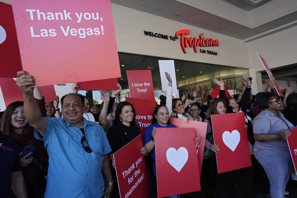 Empleados del hotel y casino Tropicana sostienen carteles durante una ceremonia que marca el cierre del sitio histórico el martes 2 de abril de 2024, en Las Vegas. Está previsto que el hotel-casino sea demolido en octubre para dar espacio a un estadio de béisbol de 1.500 millones de dólares. (Foto AP/John Locher)