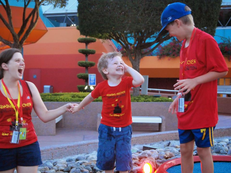 kari and her two sons climbing benches at disney world