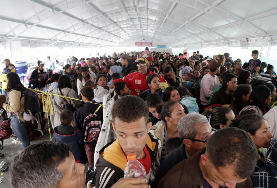 Venezuelans line up at an immigration processing office on the Rumichaca bridge, before crossing the border from Colombia to Ecuador, Thursday, June 13, 2019. Venezuelan migrants are making their way to Peru, where on June 15, the country will start requiring them to have a passport and a humanitarian visa. (AP Photo/Dolores Ochoa)