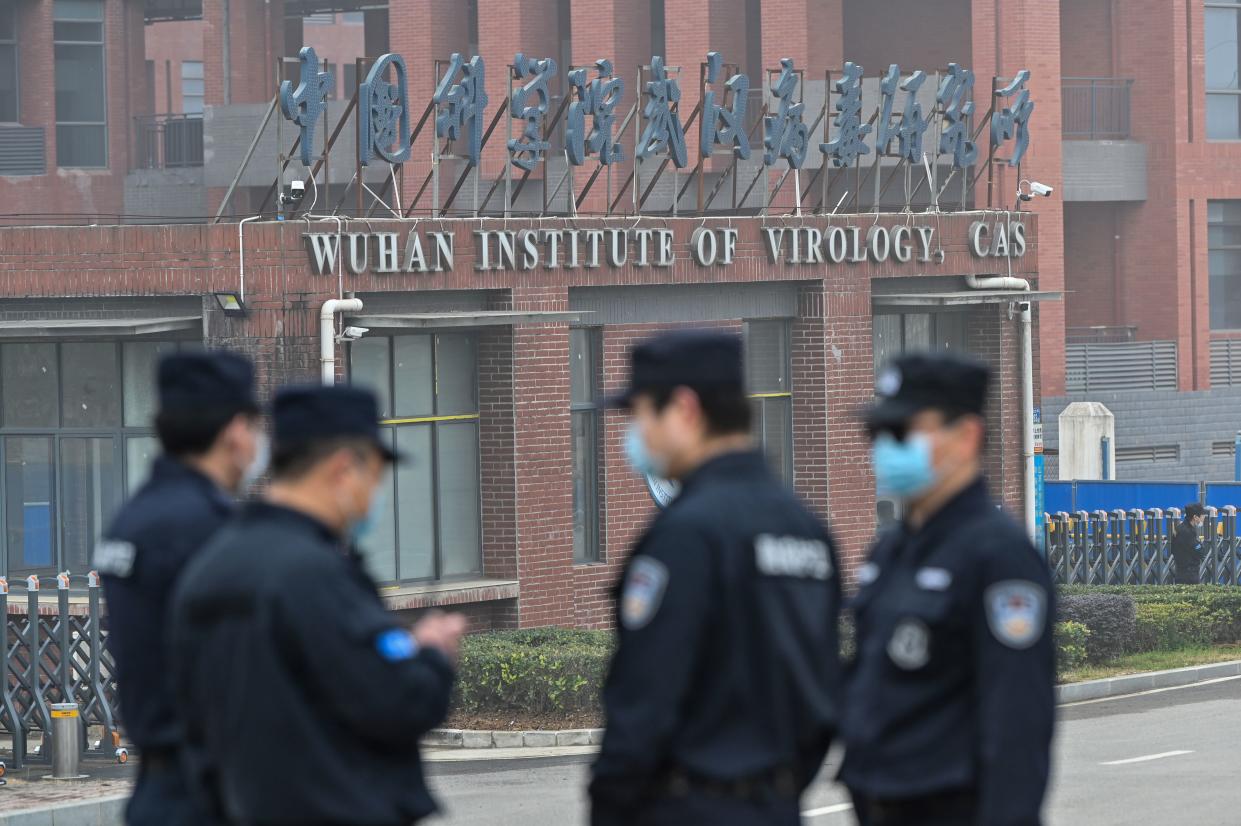 Security personnel in masks stand guard outside the Wuhan Institute of Virology in Wuhan, which is marked: Wuhan Institute of Virology, CAS. 