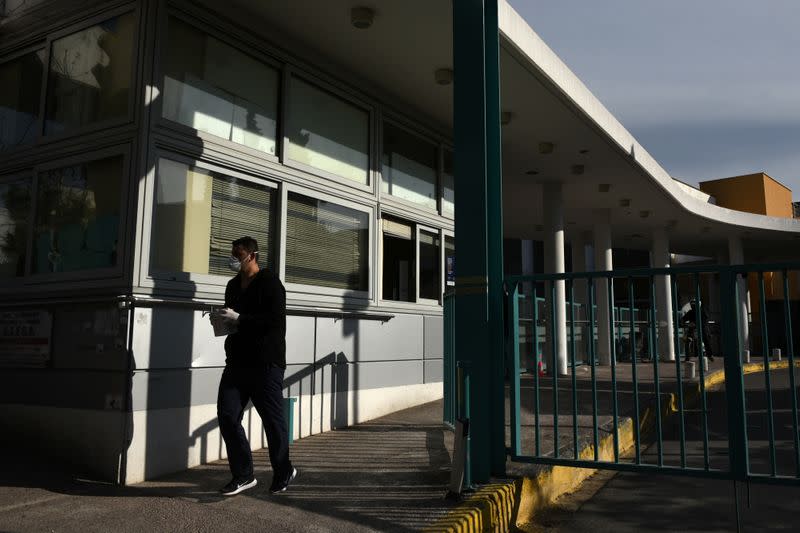 People wearing protective face masks are seen outside the AHEPA hospital, where the first confirmed coronavirus case is being treated, in Thessaloniki