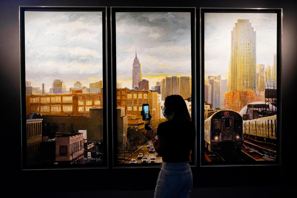 A student takes a photo of Bob Dylan's "Subway Cityscape Triptych" painting.