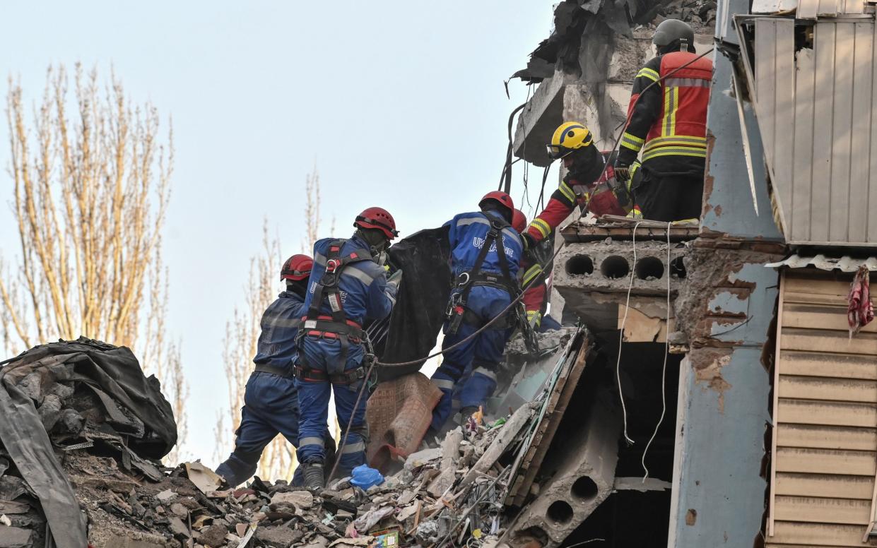 Rescuers carry the body of a resident in Zaporizhzhia - Reuters