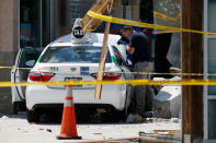 <p>An official photographs the scene where police say a taxi driver struck a group of pedestrians, injuring several, Monday, July 3, 2017, in Boston. A police official said the crash is believed to be a case of “operator error” in which the driver stepped on the gas pedal instead of the brake. (AP Photo/Michael Dwyer) </p>