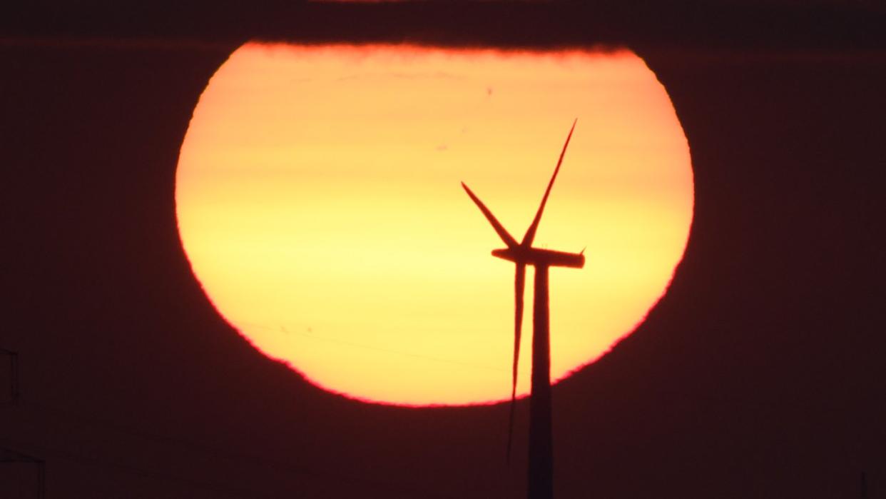 Sonnenaufgang hinter einem Windrad. Deutschland ist im Klima-Ranking abgerutscht. Foto: Julian Stratenschulte