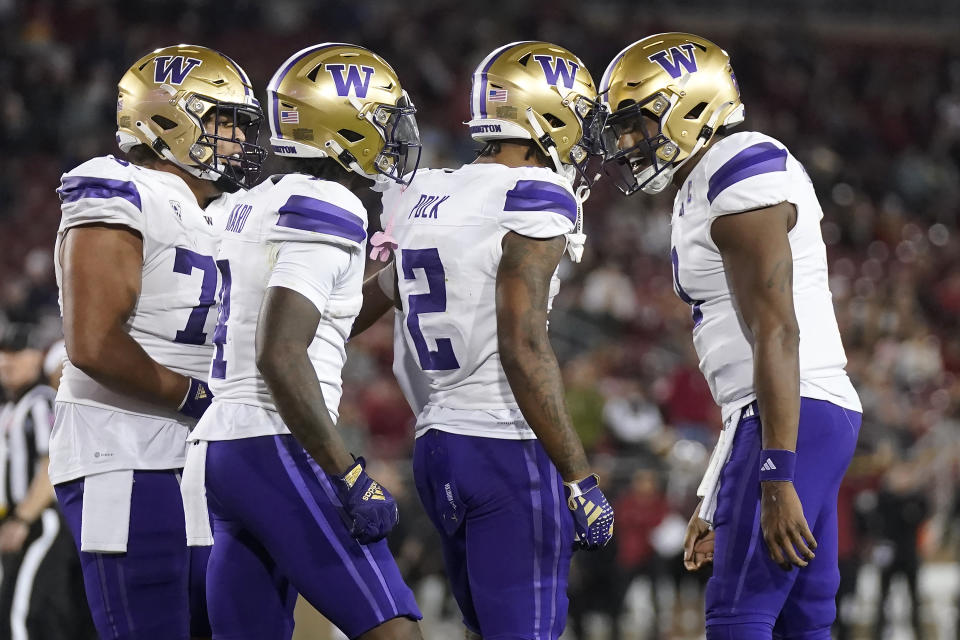 Washington wide receiver Ja'Lynn Polk (2) is congratulated by quarterback Michael Penix Jr., right, after scoring against Stanford during the second half of an NCAA college football game in Stanford, Calif., Saturday, Oct. 28, 2023. (AP Photo/Jeff Chiu)