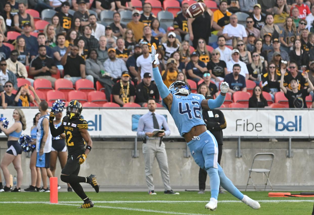 Canadian Football League Toronto Argonauts defensive back Qwan'tez Stiggers reaches up to intercept a pass intended for Hamilton Tiger-Cats wide receiver Tim White in the first quarter at BMO Field on June 18, 2023.