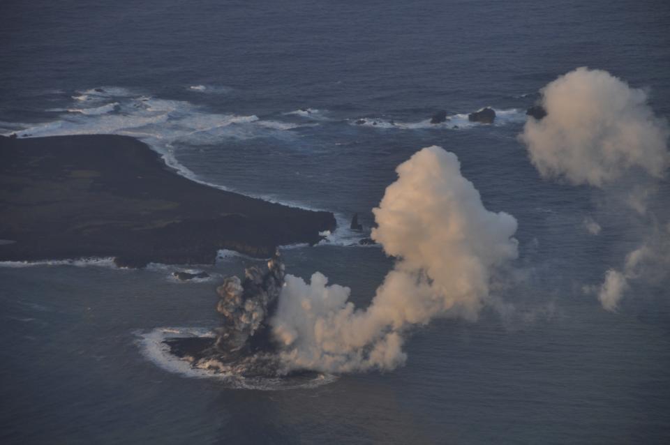 Smoke from an erupting undersea volcano forms a new island off the coast of Nishinoshima (top L), a small uninhabited island, in the southern Ogasawara chain of islands in this November 20, 2013 picture provided by the Japan Coast Guard. Japan added another small area to its territory on Wednesday after the undersea volcano eruption in the southern Ogasawara chain of islands led to the birth of a small new one. Picture taken November 20. Mandatory Credit REUTERS/Japan Coast Guard/Handout via Reuters