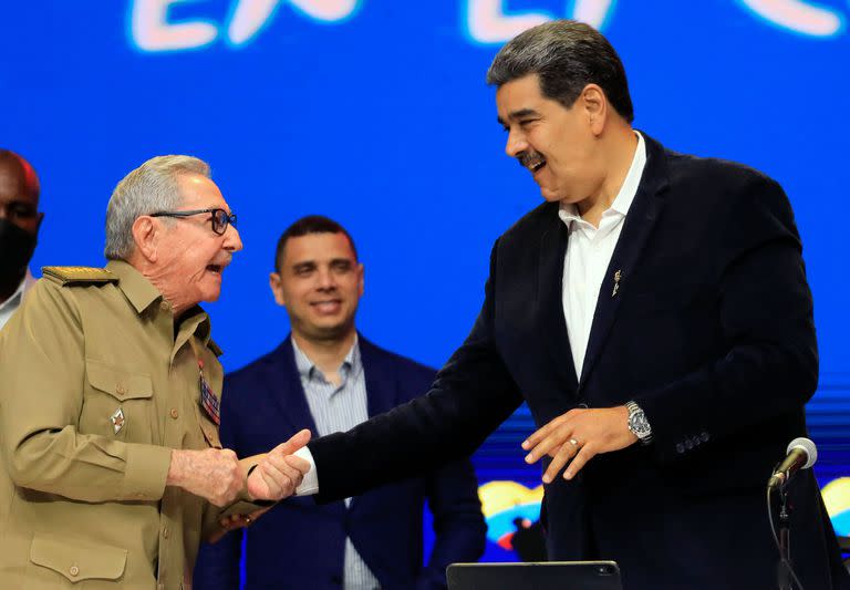 Fotografía cedida por la oficina de prensa de la Presidencia venezolana que muestra al presidente de Venezuela, Nicolás Maduro, conversando con el ex presidente de Cuba, Raúl Castro, durante el acto conmemorativo por el décimo aniversario de la muerte del presidente venezolano Hugo Chávez, en el Teatro Teresa Carreño de Caracas, el 5 de marzo de 2023.