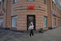 A woman walks past an H&M store in Moscow