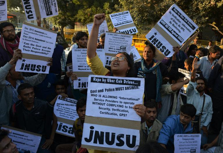 Indian residents hold placards and chant slogans as they take part in a protest against the alleged rape of a passenger by a driver working for Uber in New Delhi on December 7, 2014