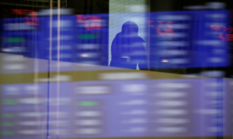 A visitor is seen as market prices are reflected in a glass window at the Tokyo Stock Exchange (TSE) in Tokyo, Japan, February 6, 2018. REUTERS/Toru Hanai