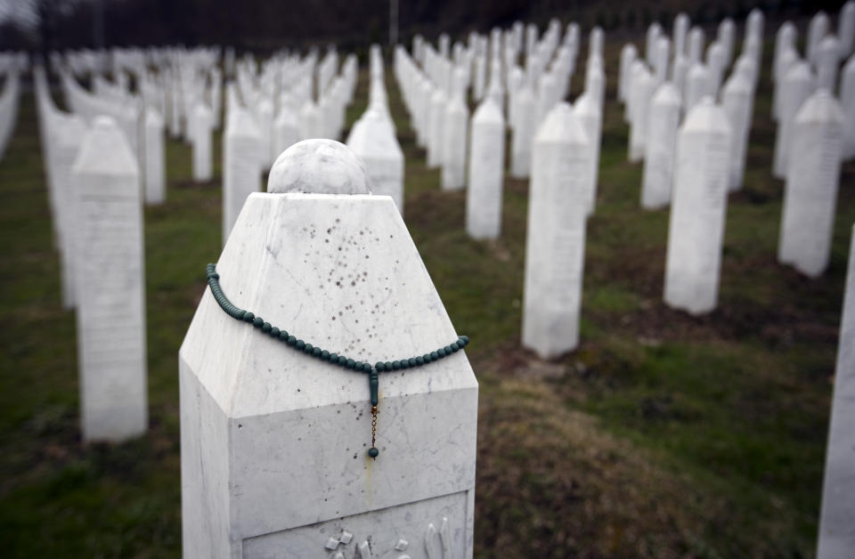 In this Saturday, March 16, 2019 photo, a chaplet hangs on a tomb at the memorial cemetery for massacre victims in Potocari, near Srebrenica, Bosnia-Herzegovina. Nearly a quarter of a century since Bosnia's devastating war ended, former Bosnian Serb leader Radovan Karadzic is set to hear the final judgment on whether he can be held criminally responsible for unleashing a wave of murder and mistreatment by his administration's forces. United Nations appeals judges on Wednesday March 20, 2019 will decide whether to uphold or overturn Karadzic's 2016 convictions for genocide, crimes against humanity and war crimes and his 40-year sentence. (AP Photo/Darko Bandic)