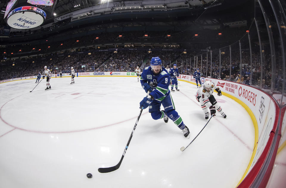 Vancouver Canucks' J.T. Miller (9) skates with the puck in front of Chicago Blackhawks' Duncan Keith (2) during the second period of an NHL hockey game Wednesday, Feb. 12, 2020, in Vancouver, British Columbia. (Darryl Dyck/The Canadian Press via AP)