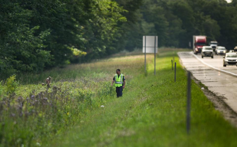 Lansing Police Dept. Det. Pete Scheccia, right, and another LPD member  search an area along eastbound Interstate 96 near the Williamston Road exit Wednesday afternoon, July 5, 2023, looking for two-year-old Wynter Cole Smith missing since July 2, 2023. LPD, the FBI, Michigan State Police, and Ingham County Sheriff's Dept. assisted in the search.