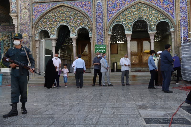 Iranians wait to vote at a polling station during presidential elections in Tehran