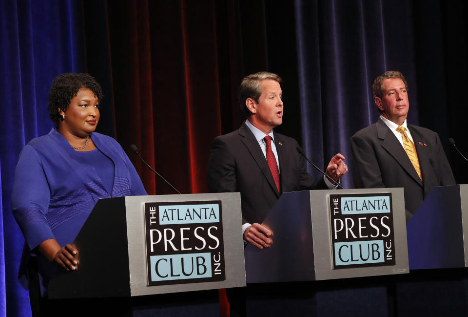 Republican gubernatorial candidate for Georgia Secretary of State Brian Kemp, center, speaks as Democrat Stacey Abrams, left, and Libertarian Ted Metz look on during a debate Tuesday, Oct. 23, 2018, in Atlanta. (AP Photo/John Bazemore, Pool)