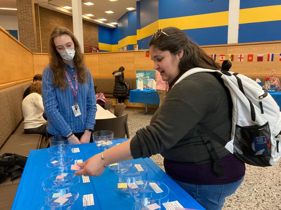 Worcester State University junior Zadia Valenze, left, explains how to fill out the food insecurity survey to senior Greter Barcelo at a fundraiser to support Thea's Pantry, the university's on-campus food pantry.