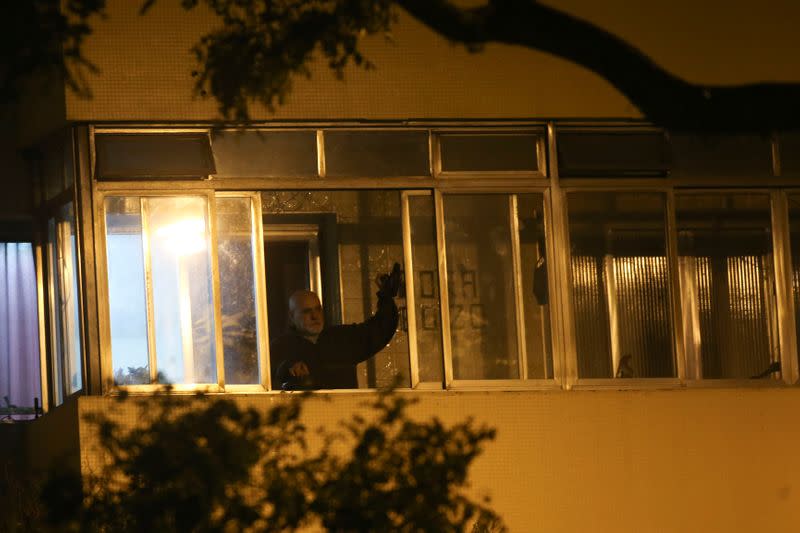 A demonstrators hits a pot lid as protest against Brazilian President Jair Bolsonaro's televised speech from the window of their home during the outbreak of the coronavirus disease (COVID-19) in Sao Paulo