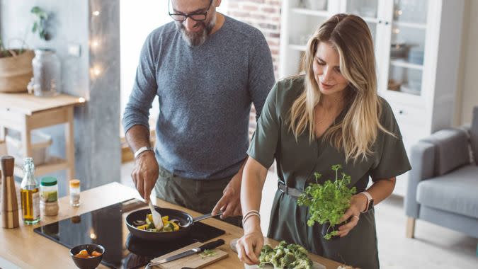 Man and woman preparing delicious vegetable meal, everything is so green, healthy and freshly harvested from garden.