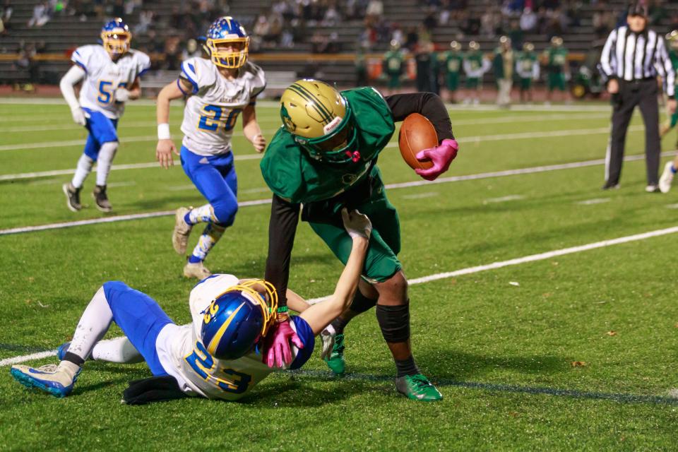 GNB Voc Tech’s Aziz Ba breaks a tackler to gain a few extra yards during the State Vocational Large semifinal against Assabet.