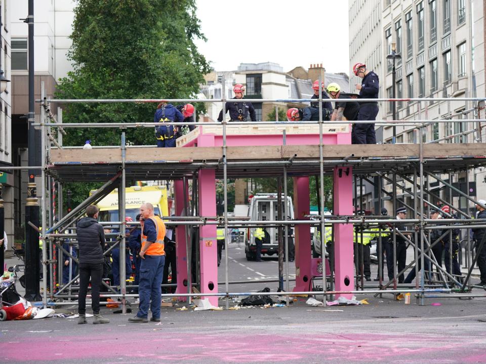 Workers remove the table, which was blocking the junction of Long Acre and Upper St Martin’s Lane, on Tuesday morning (PA)