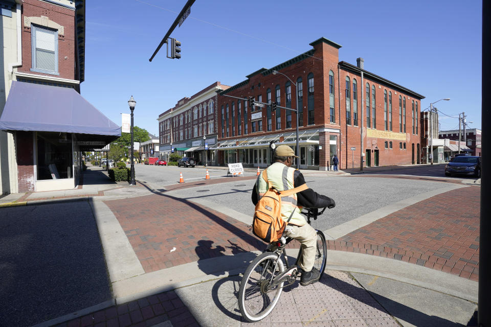 FILE - In this April 22, 2021 file photo, a man rides a bicycle downtown in Elizabeth City, N.C. The fatal shooting of a Black man by sheriff’s deputies has sent shock waves through Elizabeth City. The majority Black city in the state’s rural northeastern corner holds an important place in African American history in the 19th and 20th centuries. But some residents say it seemed too close-knit and too out-of-the-way to become a flashpoint in the 21st. (AP Photo/Gerry Broome, File)