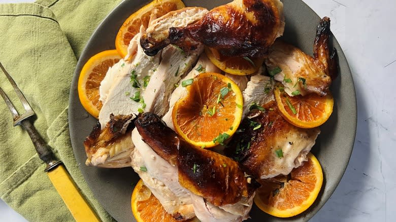 roast chicken with orange slices on gray plate