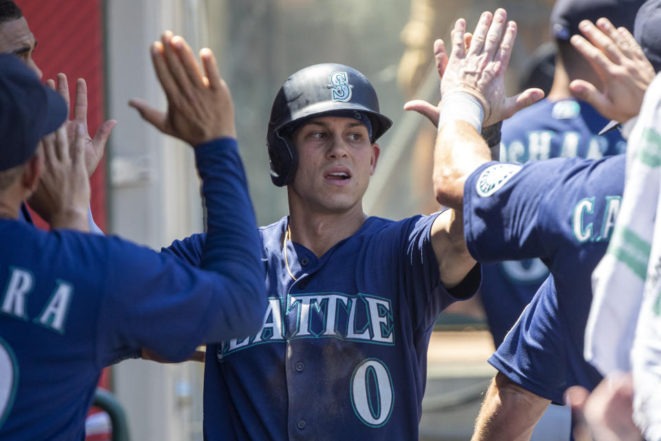 Seattle Mariners' Sam Haggerty is congratulated by teammates in the dugout after scoring against the Los Angeles Angels in the third inning of a baseball game in Anaheim, Calif., Wednesday, Aug. 17, 2022. (AP Photo/Alex Gallardo)