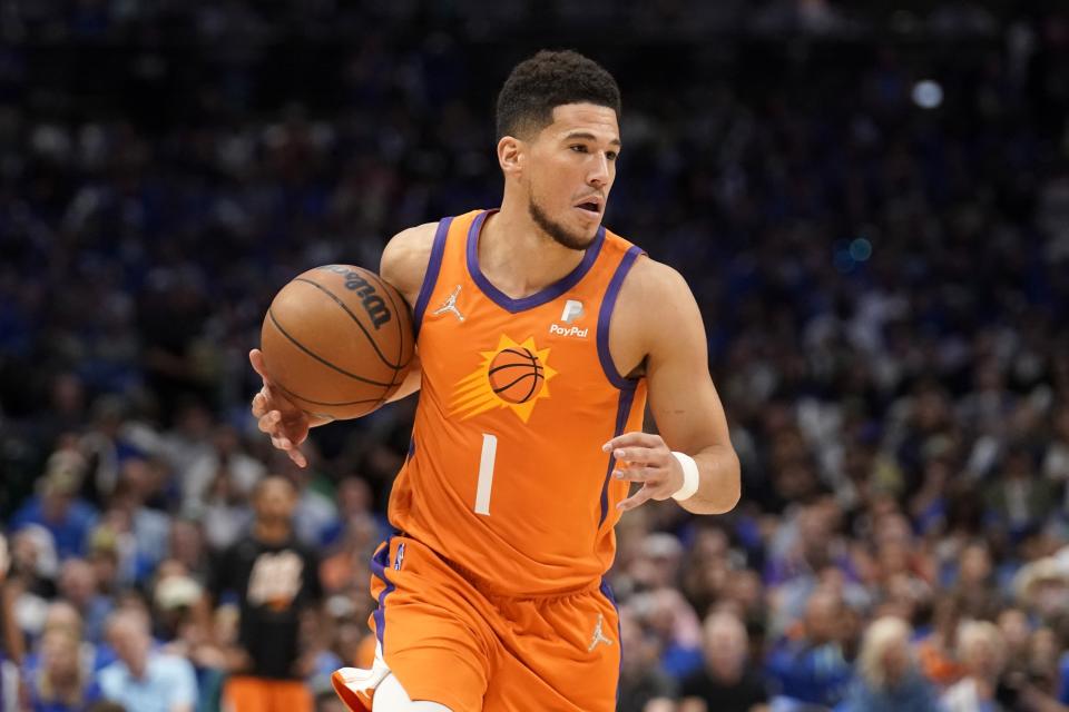 Phoenix Suns guard Devin Booker (1) advances the ball against the Dallas Mavericks in the first half of Game 4 of an NBA basketball second-round playoff series, Sunday, May 8, 2022, in Dallas. (AP Photo/Tony Gutierrez)