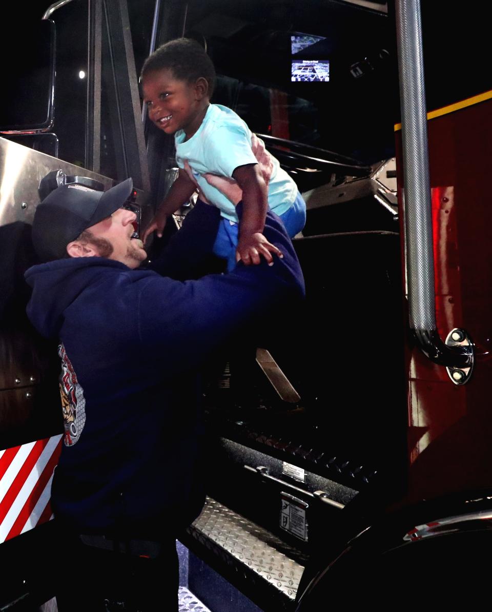 Tyler Spain an Engineer with the La Vergne Fire Department helps Kameron Robertson 2, out of a firetruck after he got to sit in the driver's seat during the National Night Out in La Vergne, on Tuesday, Oct. 4, 2022, at Veterans Memorial Park.