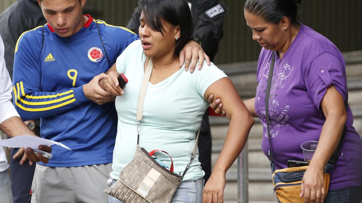 Eine Überlebende wird nach ihrer Aussage bei der Polizei von Familienangehörigen begleitet. Nach der Explosion einer Tränengasgranate in einem Nachtclub in Venezuela sind mindestens 17 Menschen ums Leben gekommen. Foto: Ariana Cubillos/AP