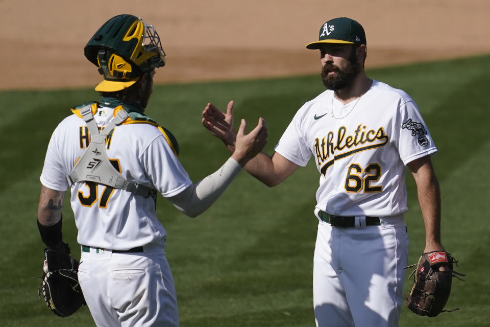 Oakland Athletics catcher Jonah Heim, left, celebrates with Lou Trivino after the Athletics defeated the San Francisco Giants in a baseball game in Oakland, Calif., Saturday, Sept. 19, 2020. (AP Photo/Jeff Chiu)