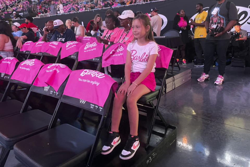 Lily Smith, 8, watches a pregame show before her first-ever WNBA basketball game Friday, Aug. 30, 2024, in Chicago. WNBA re-entered the Barbie world with Angel Reese and the Chicago Sky hosting the first-ever game themed after the doll. Lily says she likes playing with Barbies, and Barbie Night makes her feel more excited about basketball. (AP Photo/Claire Savage)