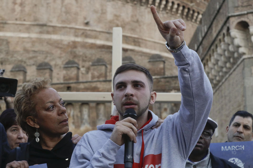 Sex abuse survivor Alessandro Battaglia, right, is hugged by survivor and founding member of the ECA (Ending Clergy Abuse), Denise Buchanan, as he speaks during a twilight vigil prayer near Castle Sant' Angelo, in Rome, Thursday, Feb. 21, 2019. Pope Francis opened a landmark sex abuse prevention summit Thursday by warning senior Catholic figures that the faithful are demanding concrete action against predator priests and not just words of condemnation. (AP Photo/Gregorio Borgia)