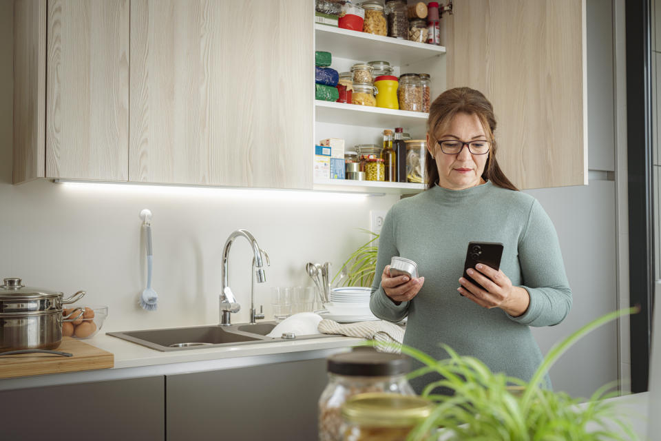 woman checking expiration date of groceriesv