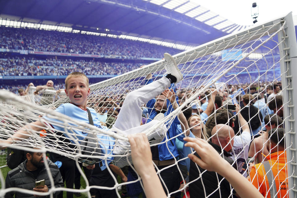 Los aficionados del Manchester City invaden la cancha luego que el equipo se coronó campeón de la Liga Premier tras vencer 3-2 a Aston Villa, el domingo 22 de mayo de 2022. (Martin Rickett/PA vía AP)