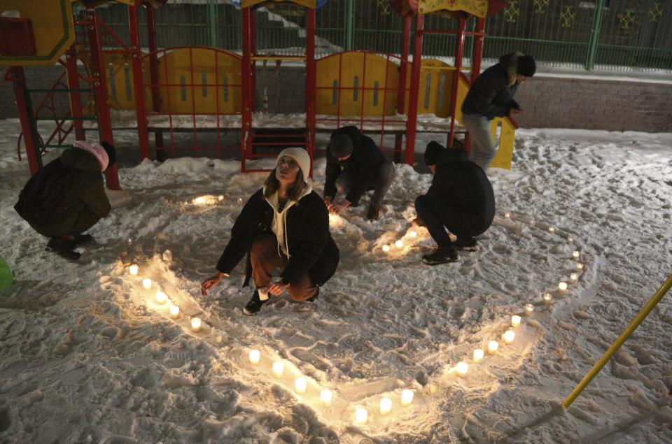 People make a heart with candles in support of jailed opposition leader Alexei Navalny and his wife Yulia Navalnaya, in the Siberian city of Omsk, Russia, Sunday, Feb. 14, 2021. When the team of jailed Russia opposition leader Alexei Navalny announced a protest in a new format, urging people to come out to their residential courtyards on Sunday and shine their cellphone flashlights, many responded with jokes and skepticism. After two weekends of nationwide demonstrations, the new protest format looked to some like a retreat. But not to Russian authorities, who moved vigorously to extinguish the illuminated protests planned for Sunday. (AP Photo)