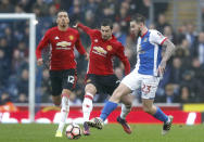 Manchester United's Henrikh Mkhitaryan, left, and Blackburn Rovers' Danny Guthrie, right, battle for the ball during the English FA Cup, Fifth Round soccer match at Ewood Park, Blackburn, England. Sunday Feb 19, 2017. (Martin Rickett/PA via AP)