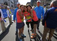 2013 Boston Marathon survivors Celeste Corcoran (C) and her daughter Sydney (R) hug together with Celeste's sister Carmen Acabbo (L), who ran the 118th Boston Marathon, after crossing the finish line in Boston, Massachusetts April 21, 2014. REUTERS/Brian Snyder (UNITED STATES - Tags: SPORT ATHLETICS)