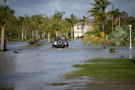 A law enforcement vehicle patrols a flooded street of in Everglades City. REUTERS/Bryan Woolston