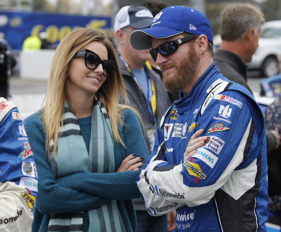 FILE - In this Sunday, Nov. 1, 2015 file photo, Sprint Cup Series driver Dale Earnhardt Jr. (88) talks with his fiance, Amy Reimann, prior to the Sprint Cup auto race at Martinsville Speedway in Martinsville, Va. NASCAR television analyst and former driver Dale Earnhardt Jr. was taken to a hospital after his plane crashed in east Tennessee. (AP Photo/Steve Helber, File)