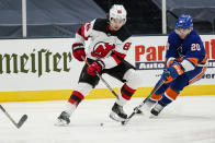 New Jersey Devils' Jack Hughes (86) vies for control of the puck with New York Islanders' Kieffer Bellows (20) during the third period of an NHL hockey game Thursday, Jan. 21, 2021, in Uniondale, N.Y. (AP Photo/Frank Franklin II)