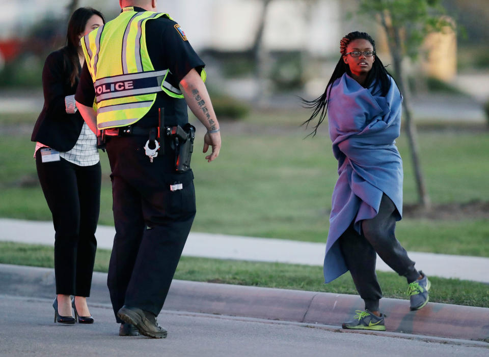 <p>An employee wrapped in a blanket talks to a police officer after she was evacuated at a FedEx distribution center where a package exploded, Tuesday, March 20, 2018, in Schertz, Texas. Authorities believe the package bomb is linked to the recent string of Austin bombings. (Photo: Eric Gay/AP) </p>