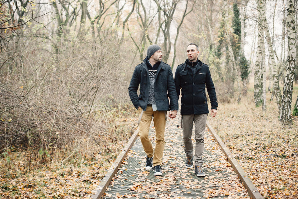 gay couple take a walk through autumn forest